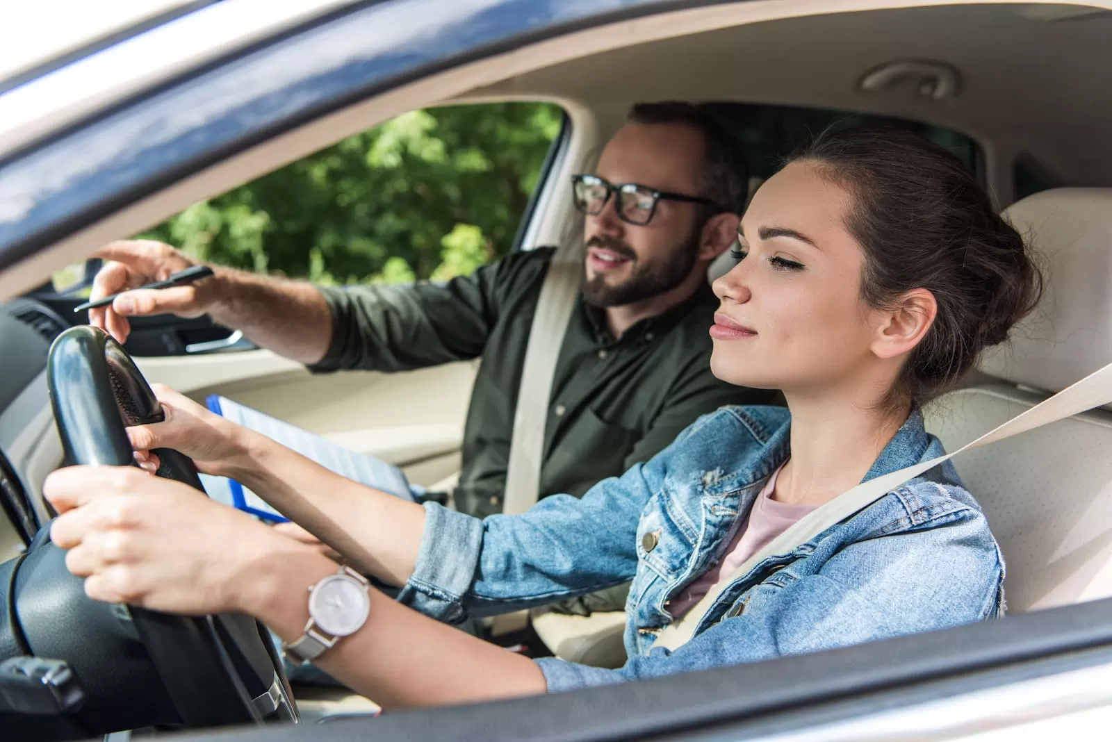 alegre estudiante y profesor en el coche en la prueba de conducción