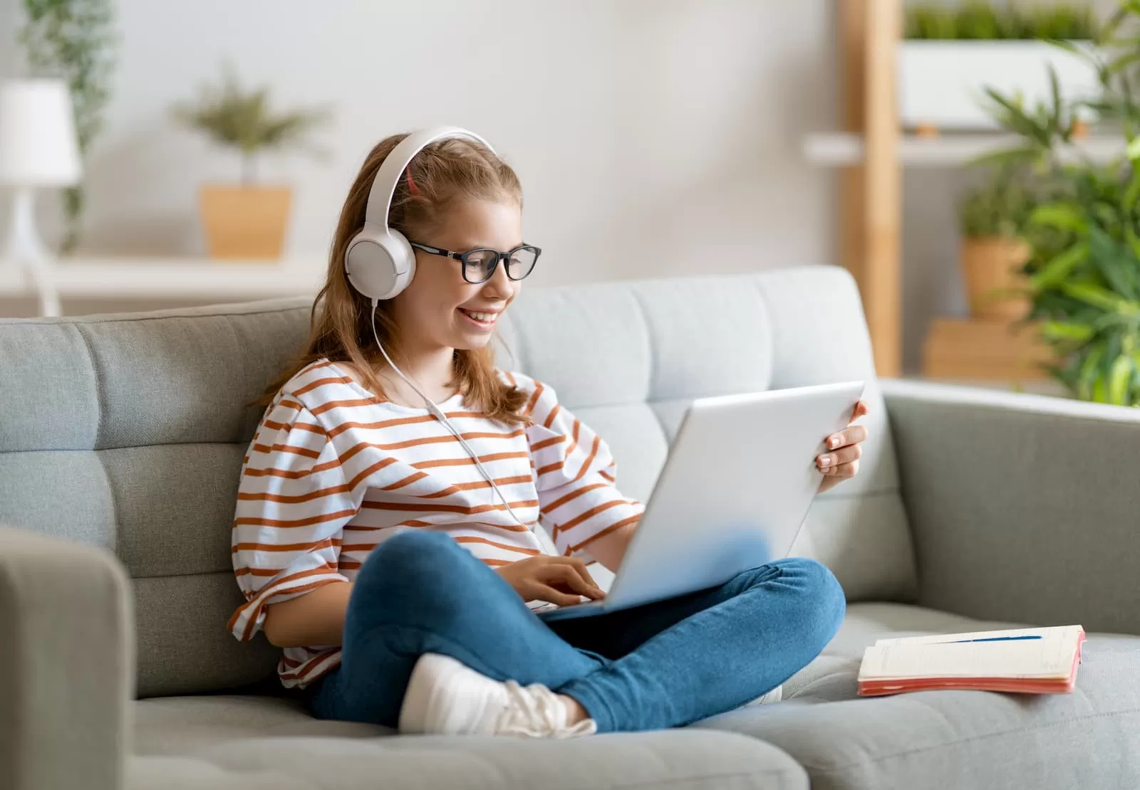 chica joven con gafas en el sofa haciendo los deberes educacion online