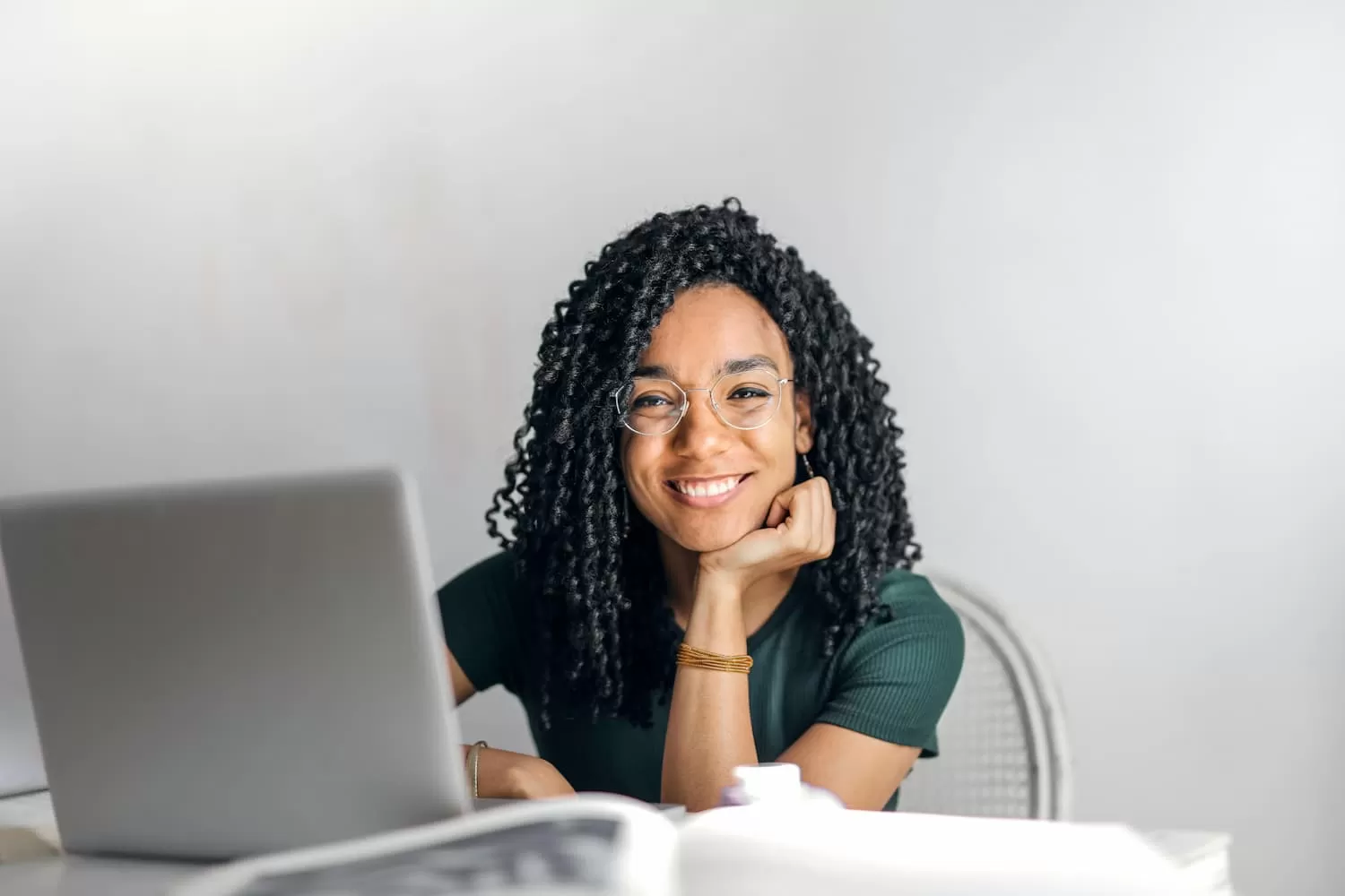 chica morena sonrie sentada con portatil