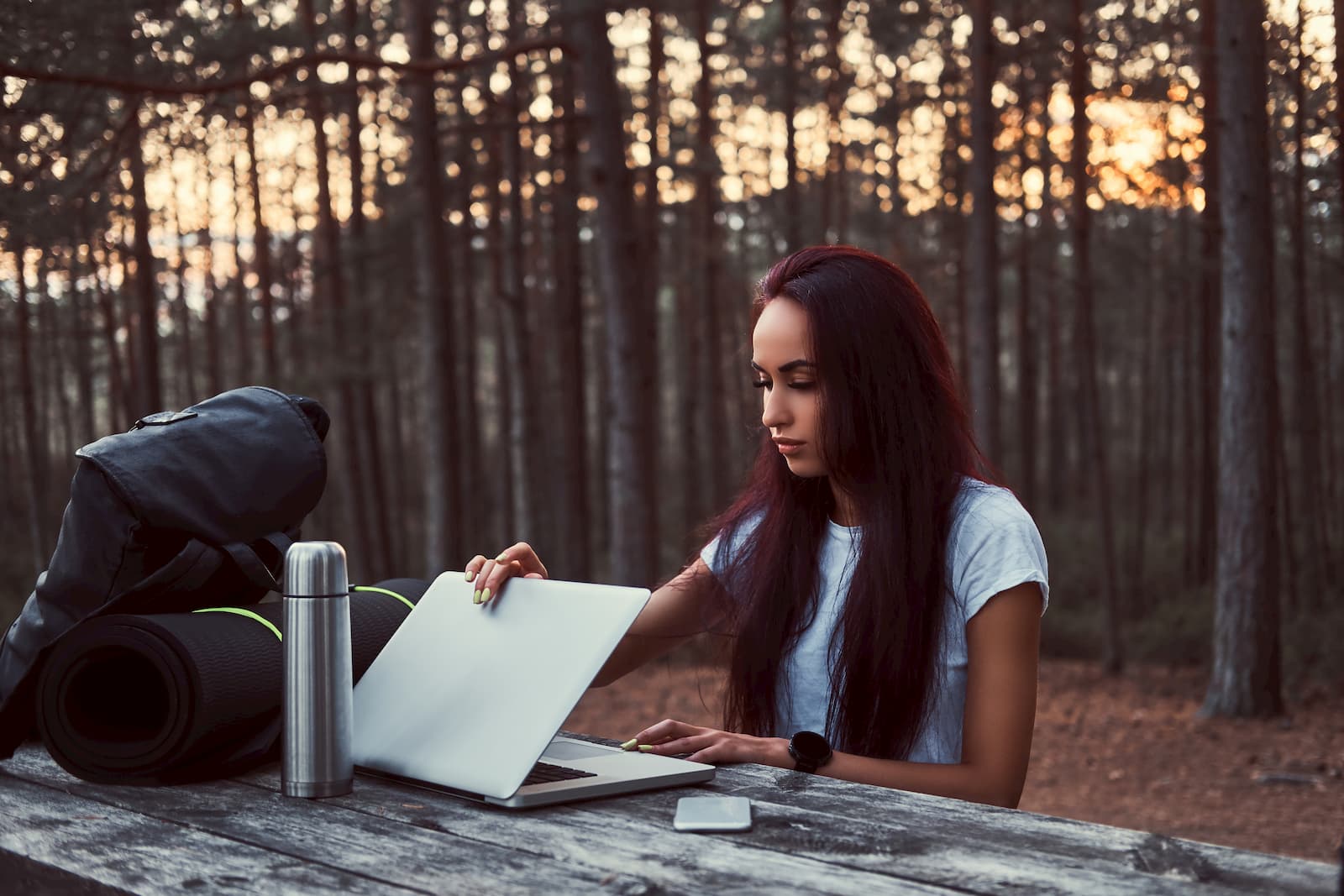 chica sentada en un banco de madera conectada por internet portatil escribe novela