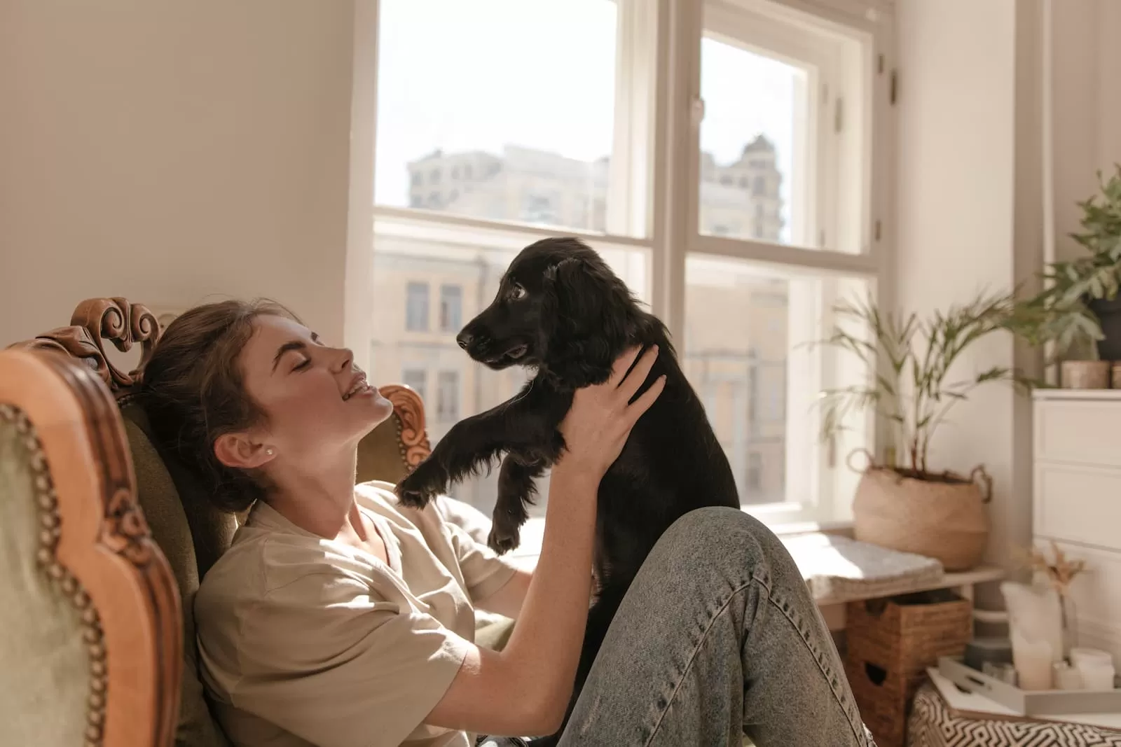 chica sentada sujeta a un perro pequeño
