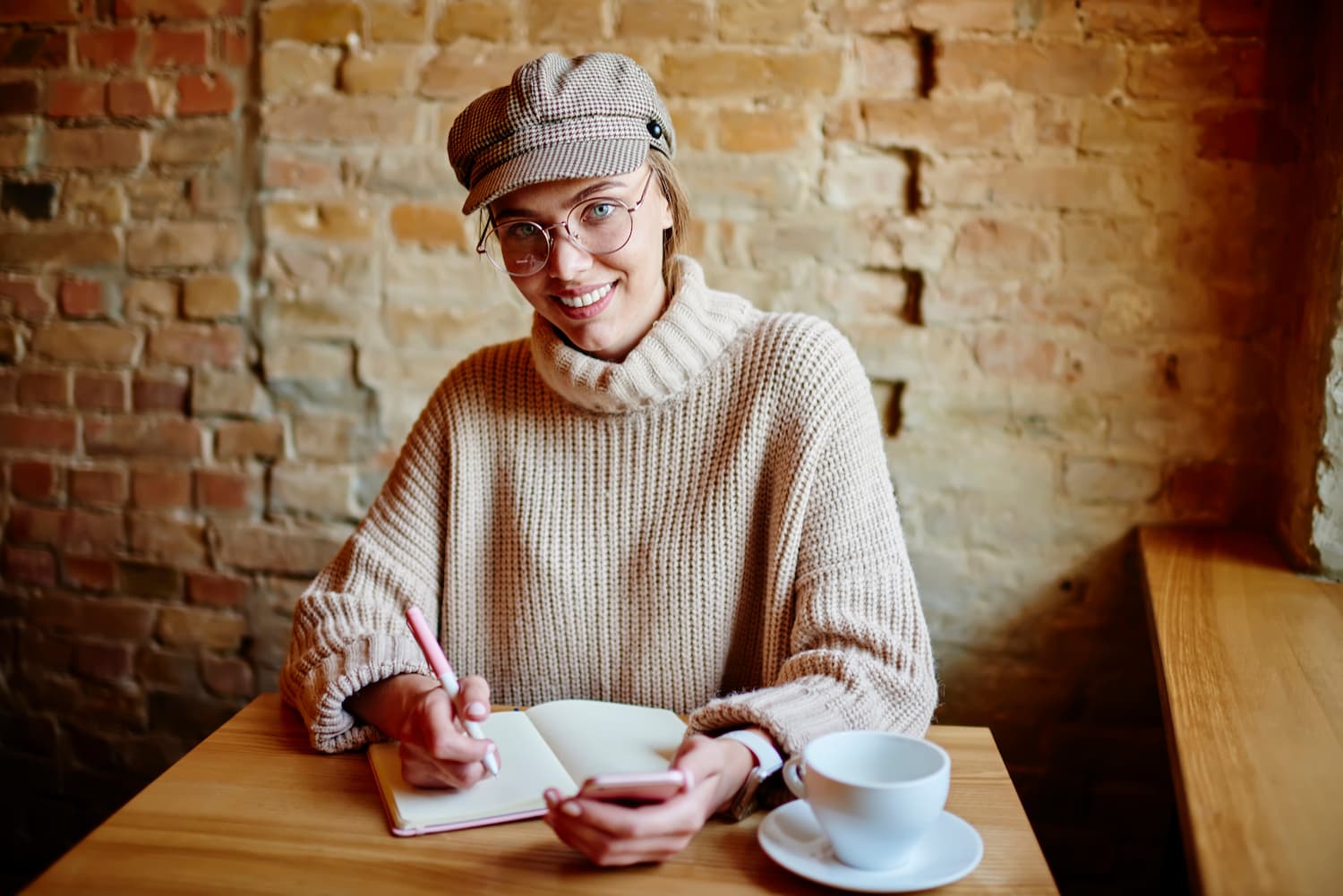 chica sonriente pelo recogido con gafas sentada con libro