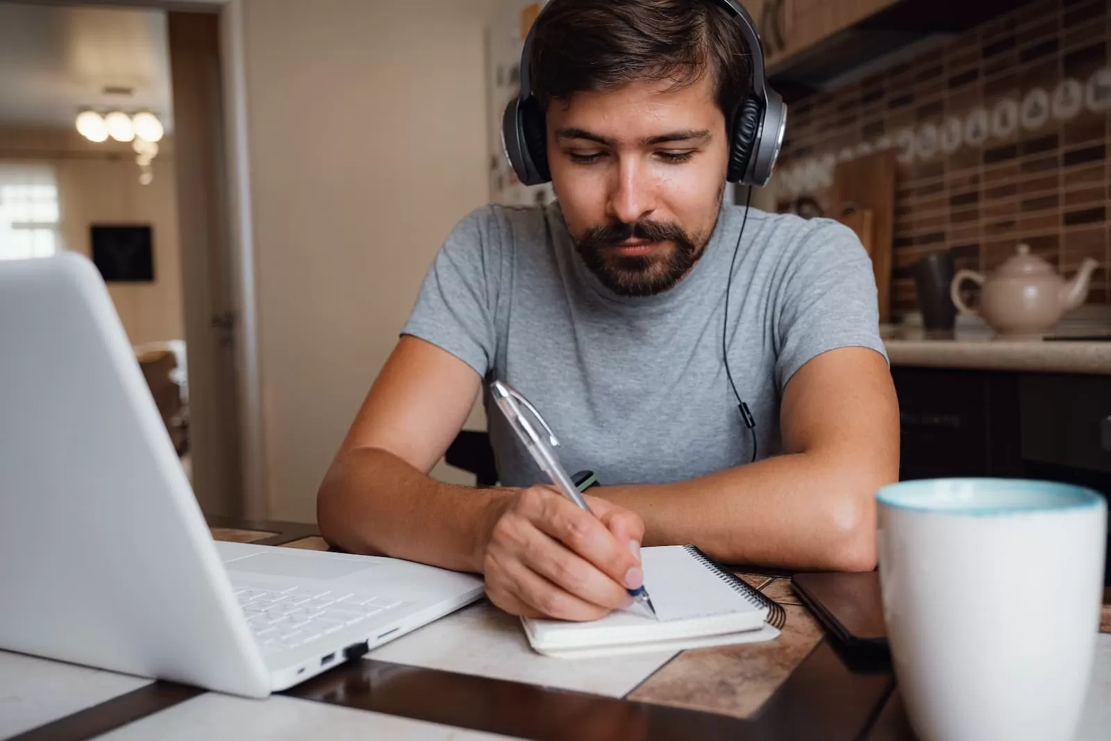 chico joven con cascos estudiando en el portatil