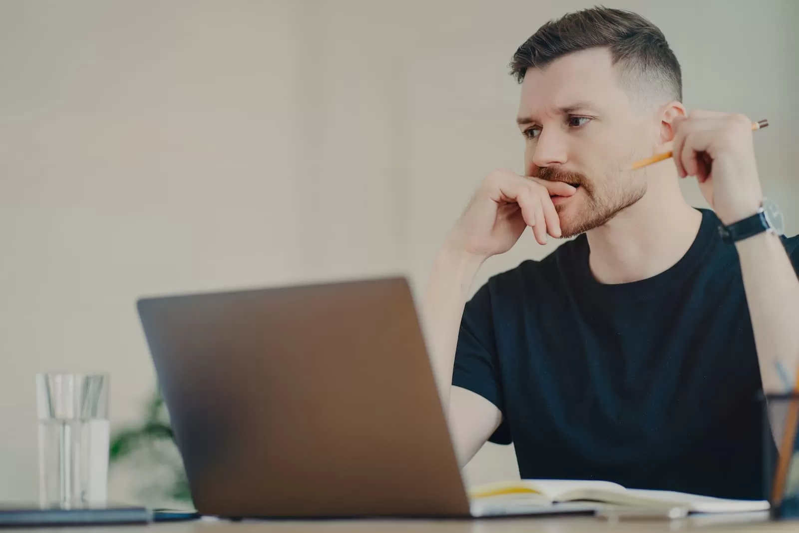 chico joven serio estudia frente el portatil sentado