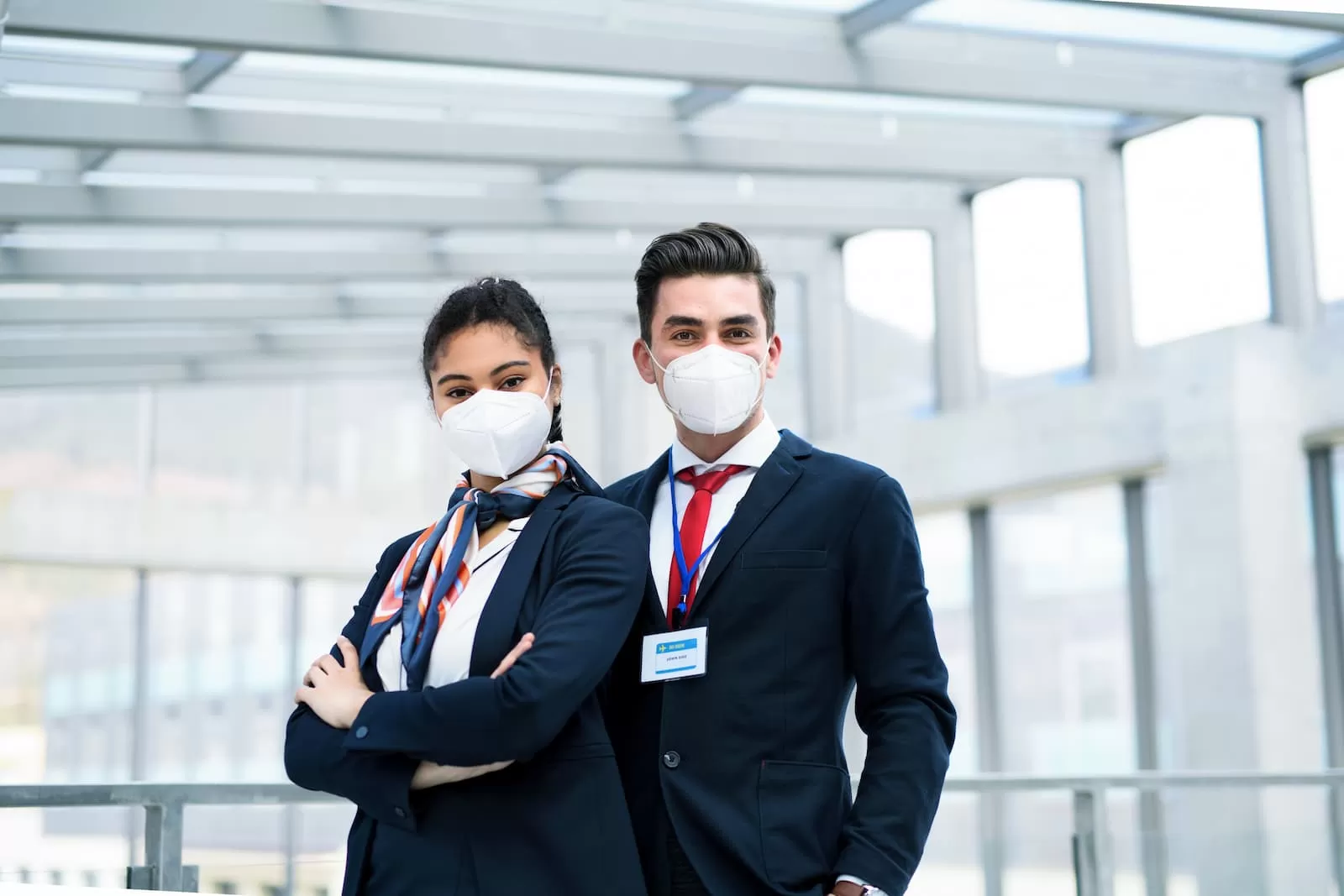 dos jovenes azafatas de vuelo en el aeropuerto con mascarilla facial
