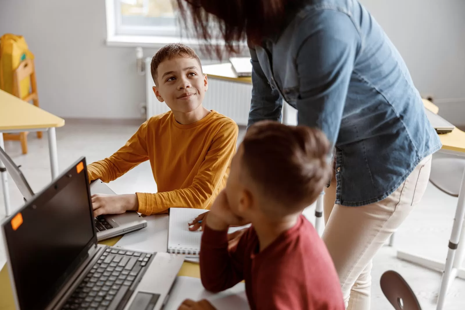 dos niños atiendes la explicacion del profesor particular