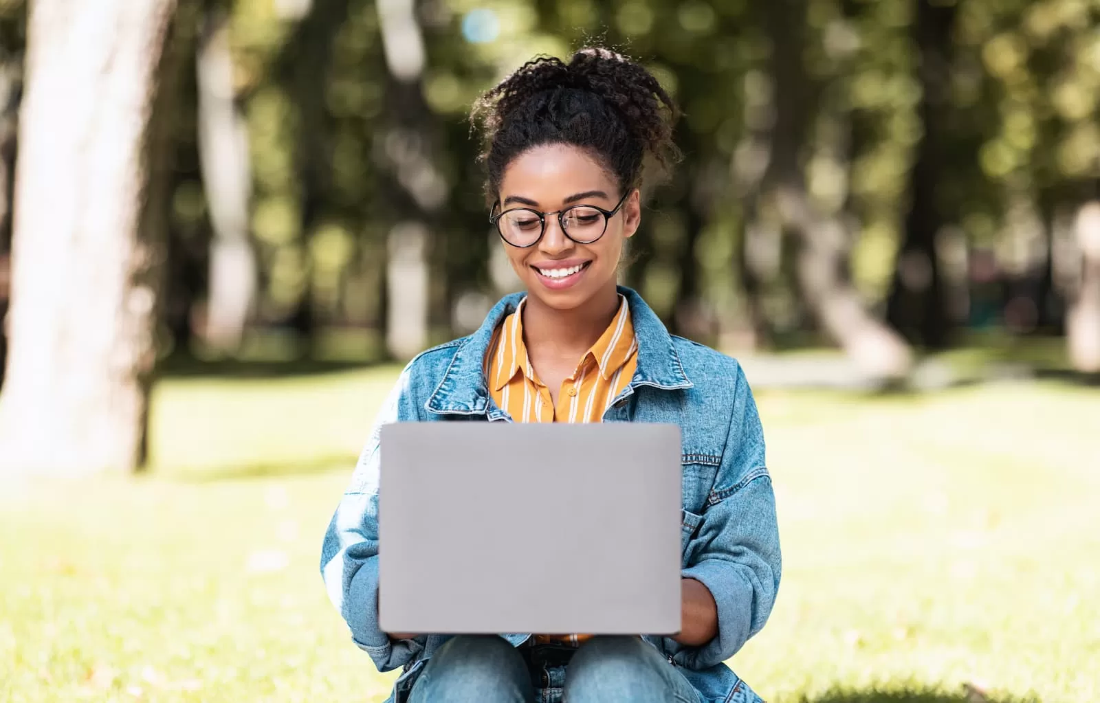 estudiante afroamericana estudiando con portatil en un parque