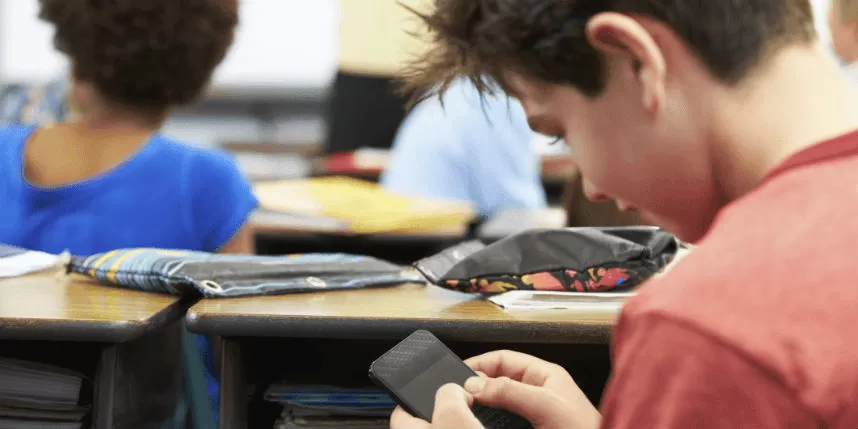 Estudiante en clase con móvil