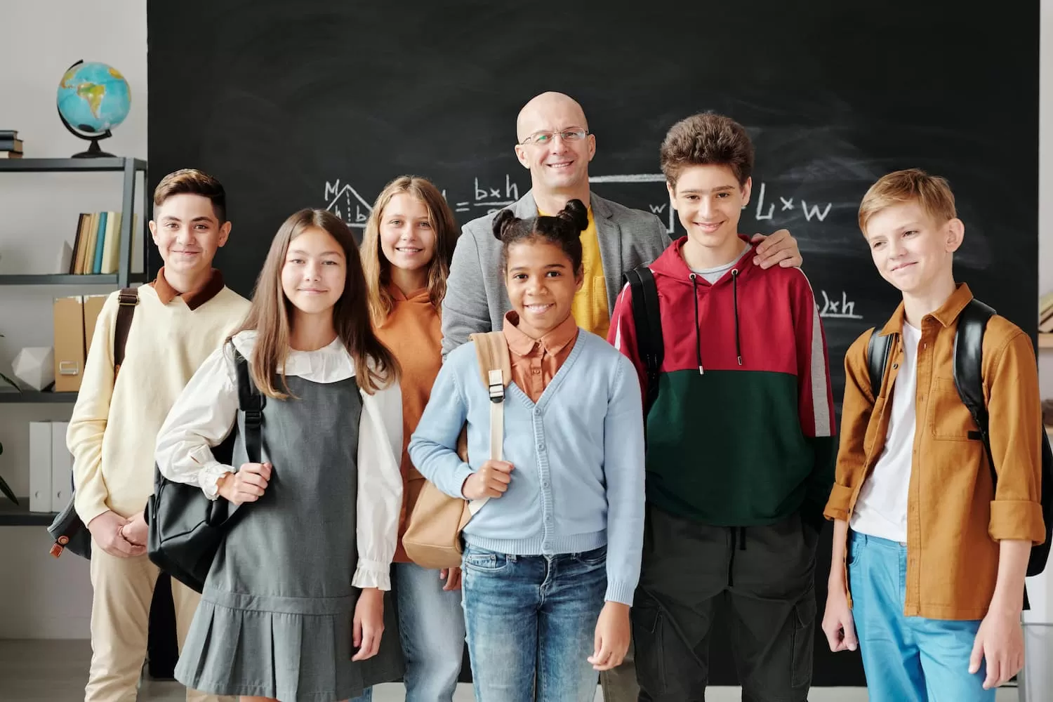 Foto de alumnos y alumnas de pie junto a su profesor