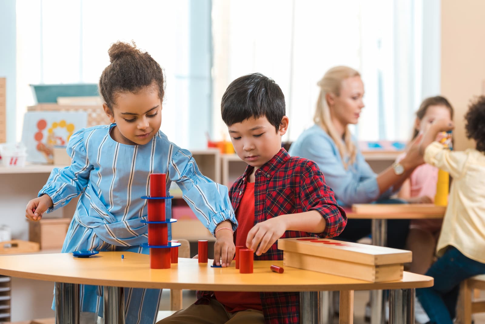 metodo montessori niño y niña jugando en la escuela sobre una mesa