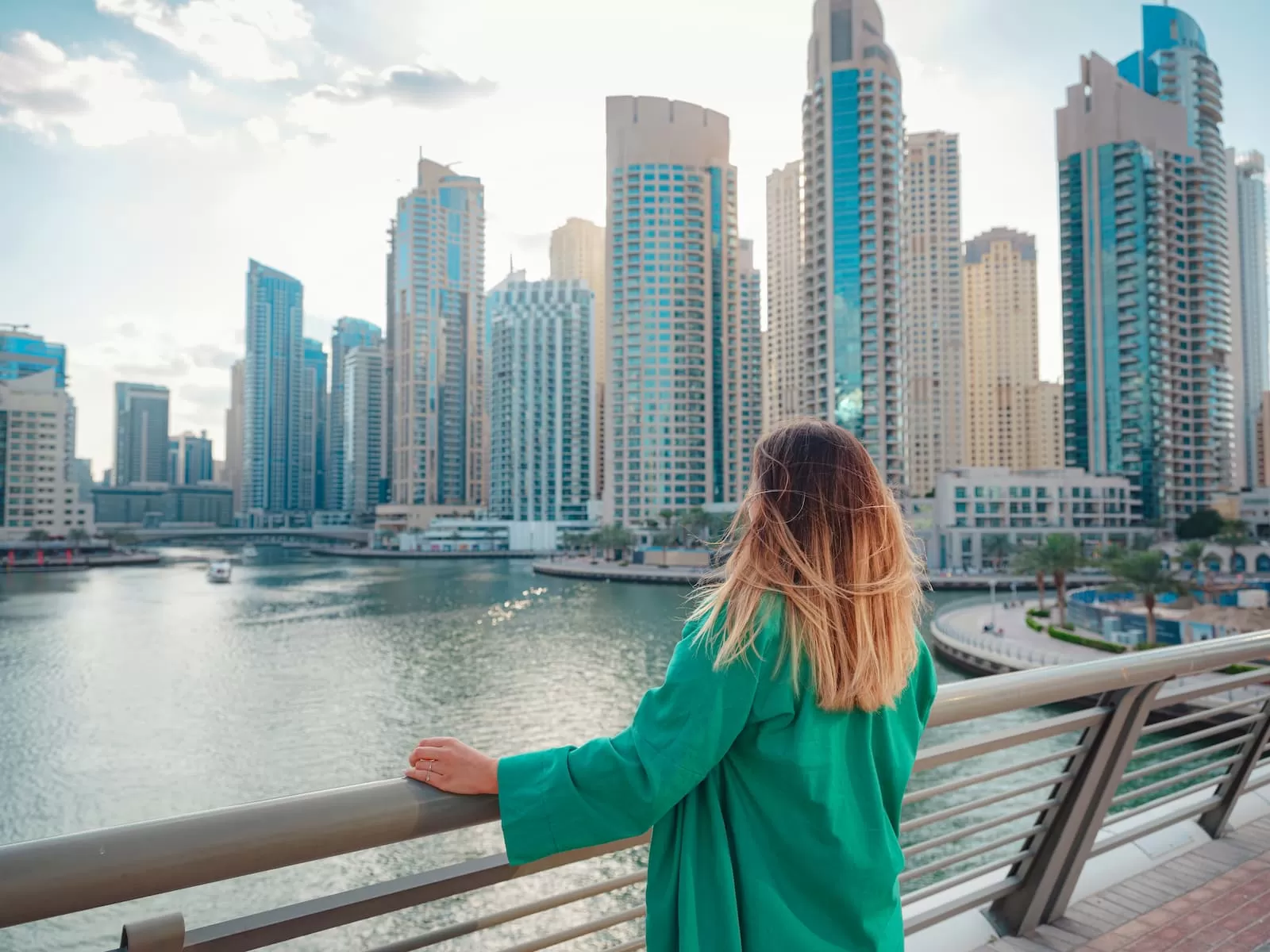 mujer camina por las calles de Dubai mira los rascacielos de espalda