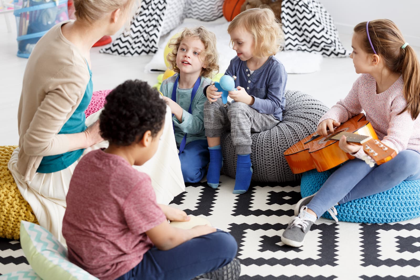 niños pequeños guarderia jardin de infantes sentados en una alfombra