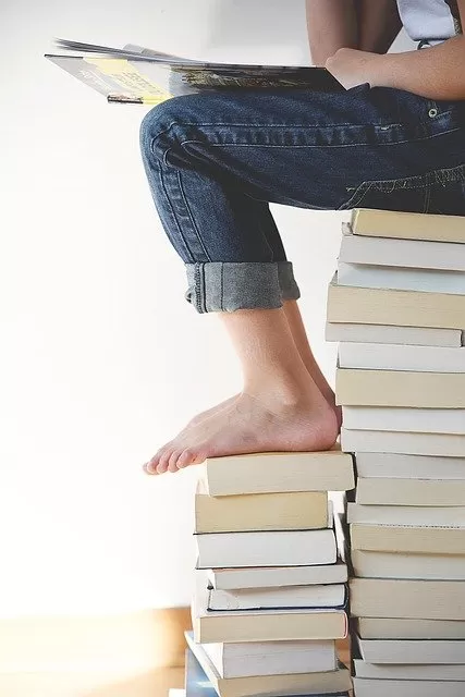 persona sentada sobre libros toma el control de tus libros imprimir libros es facil
