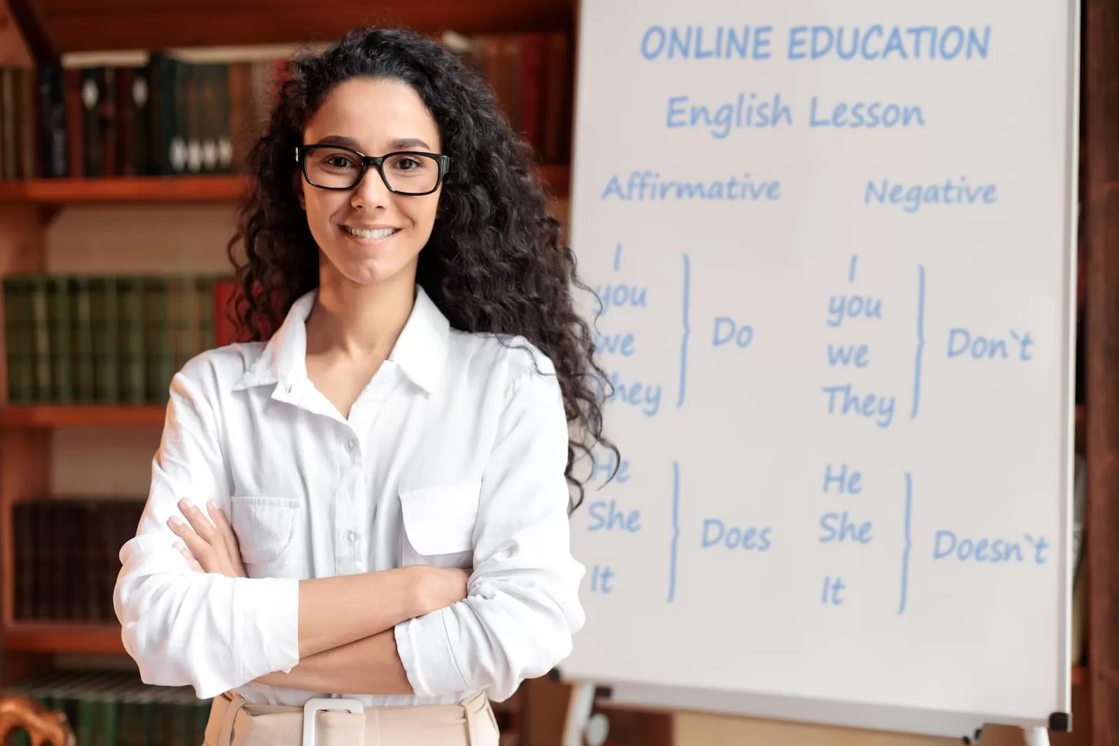 profesora de ingles de pie junto a una pizarra