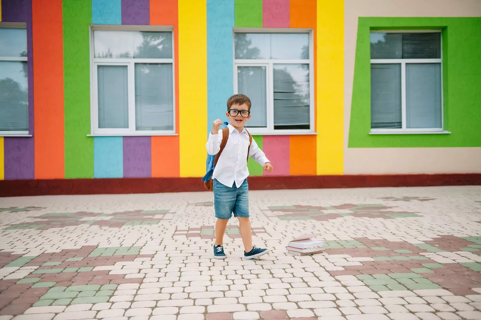 regreso a la escuela un niño feliz y sonriente con gafas va a la escuela por primera vez