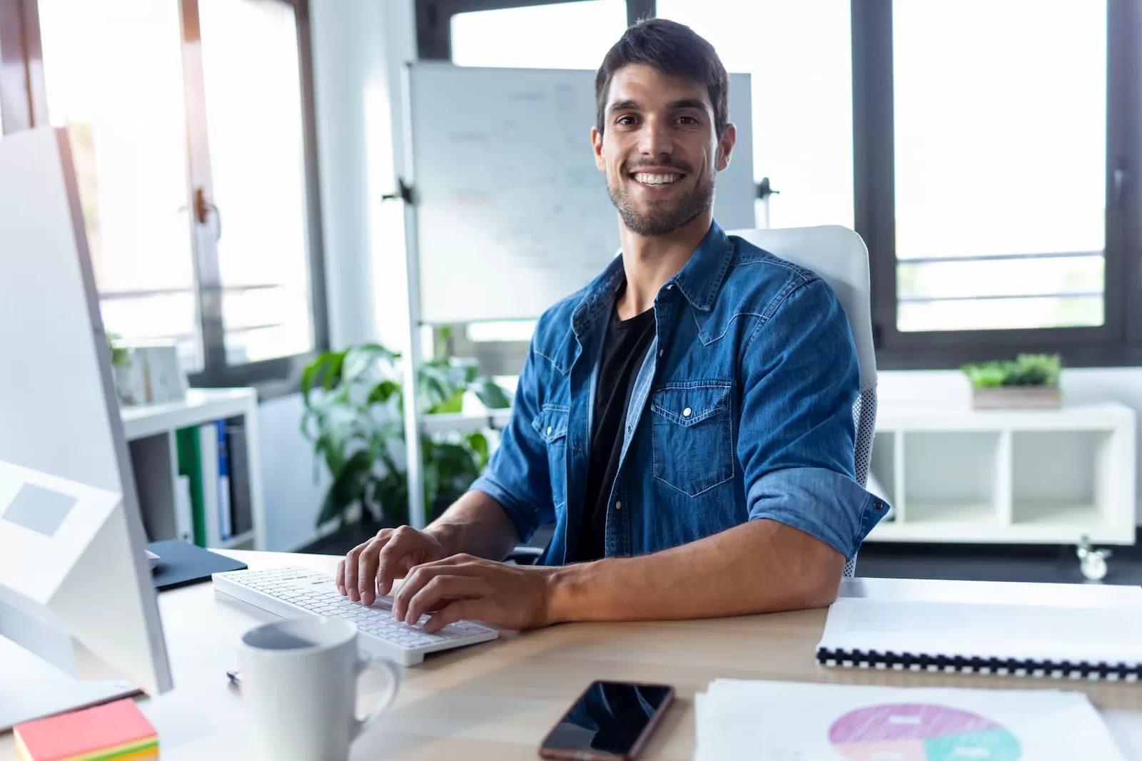 social media manager sonriendo mientras trabaja frente al ordenador