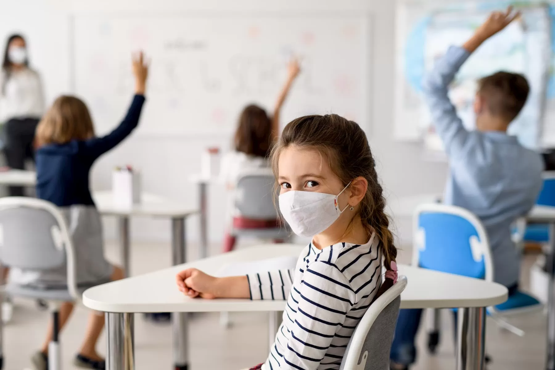 vuelta al colegio 2020 coronavirus nina sentada pupitre