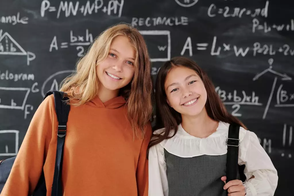 dos jovenes estudiantes sonrien de pie en la academia