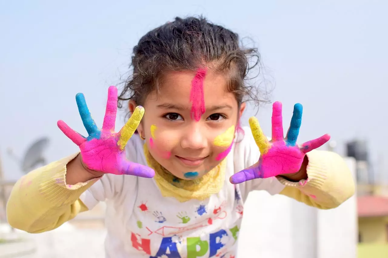 Niña pequeña con pintura en las manos